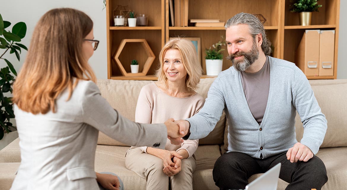 happy mature bearded man giving hand to lawyer